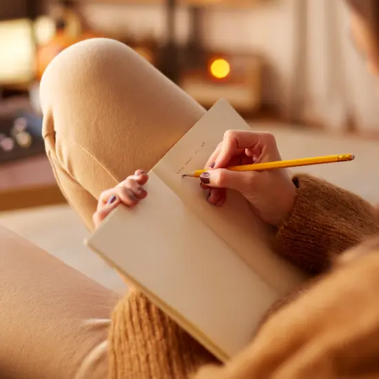 Women writing on their sofa